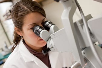 medical student looking at microscope