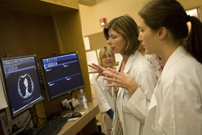 Group of medical students learning from a doctor in front of a computer