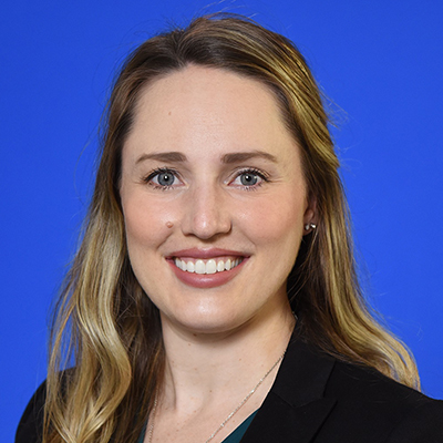 A formal headshot photo of Katherine Shaum, MD, wearing a black jacket in front of a blue background