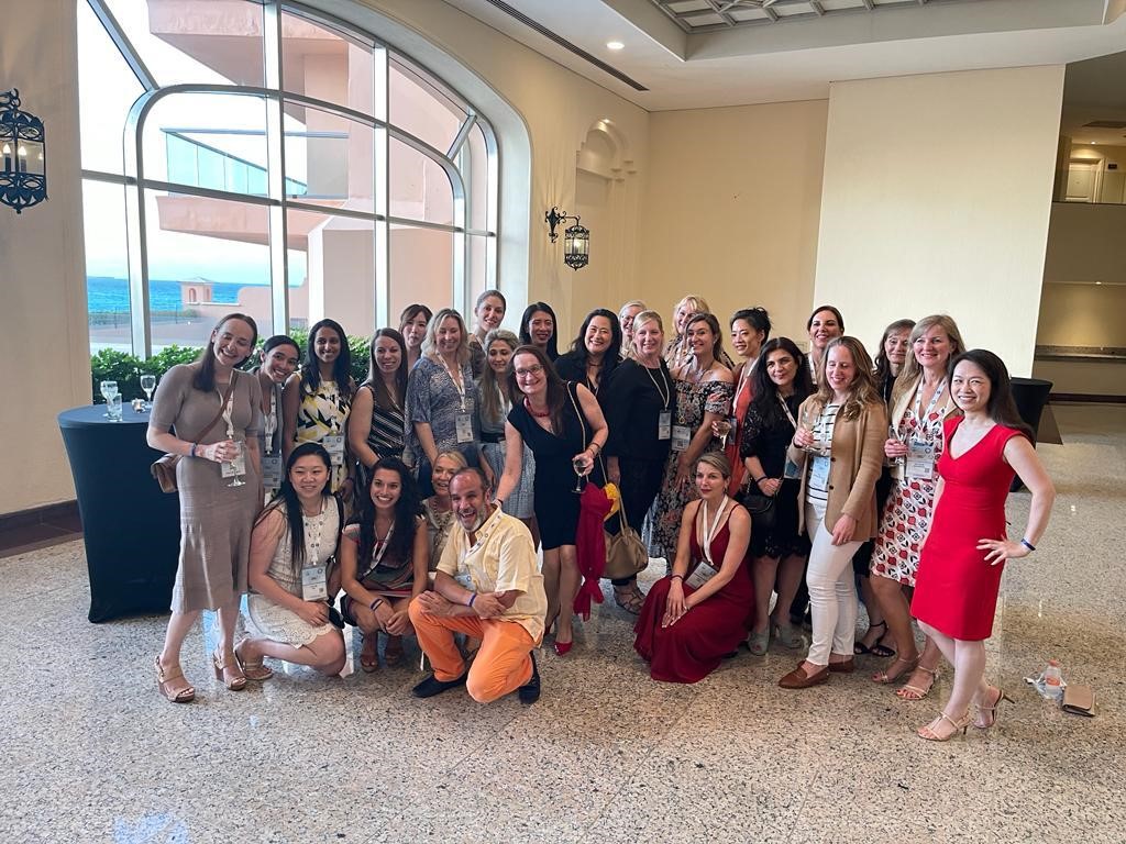A group of 27 people smile in a group photo, all in formal dress, at the inaugural meeting of the International Women in Microsurgery Group.