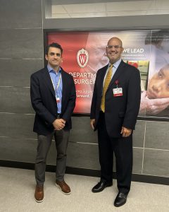 Dr. David Blitzer and Dr. John Stulak stand together for a picture in front of a UW Crest