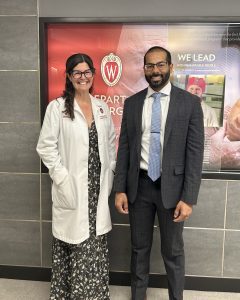 Drs. Dana Hayden and Shahrose Rahman stand next to each other for a picture in front of the UW Crest